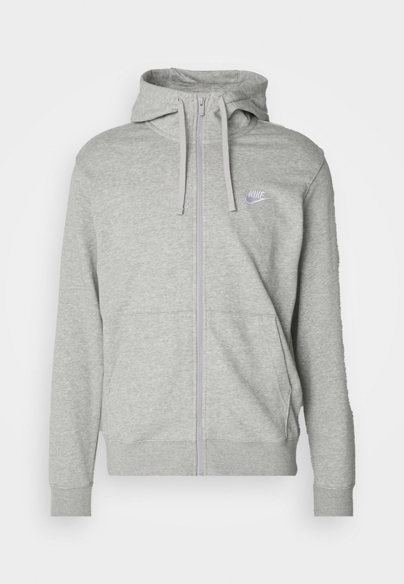 Sudadera gris con cremallera, con un bolsillo tipo canguro, capucha ajustable y un pequeño logo de Nike en púrpura en el pecho. Fabricada con un tejido suave y texturizado.