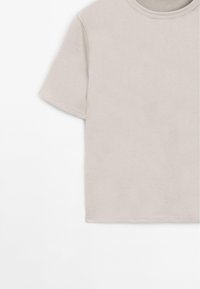 Lys grå, kortærmet T-shirt med rund hals, lavet af blødt stof. Har et enkelt design uden særprægede mønstre eller detaljer.