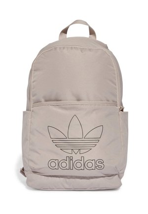 Beżowy plecak Adidas z przednią kieszenią na zamek błyskawiczny oraz czarnym logo trefoil Adidas i napisem z przodu, wyposażony w górny uchwyt do noszenia.