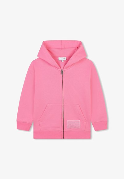 Felpa rosa con zip in tessuto morbido, dotata di tasca a marsupio, polsini a costine e un patch decorativo sulla tasca sinistra. Presenta un ampio cappuccio.