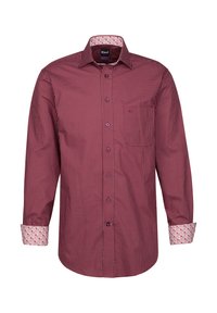 Camicia rossa a maniche lunghe con un piccolo motivo a pois bianchi, polsini interni a fiori a contrasto e taschino sul petto. Realizzata in tessuto leggero.