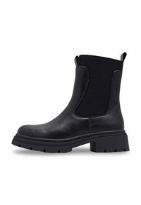 Bottines en cuir noir avec des panneaux latéraux extensibles, des tirettes, une semelle crantée épaisse et un petit talon, présentées de profil sur un fond blanc.