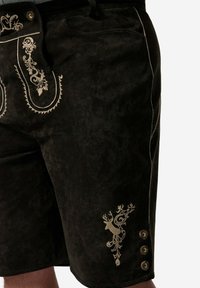 Svarta mockashorts med intrikata guldbroderier och dekorativa knappar. Designen inkluderar ett stiliserat älgmotiv och sidofickor.