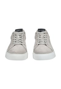 Pár světle šedých semišových tenisek s bílými podrážkami a šedými tkaničkami, s černou štítkem označeným "GANT" na jazyku.