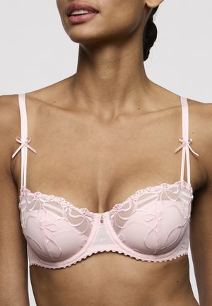 Lichtroze kanten bh met geborduurde bloemmotieven, decoratieve strikjes op de bandjes en geschulpte randen. Heeft een kleine strasssteendecoratie.