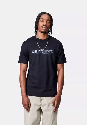Camiseta de algodón negra con mangas cortas y cuello redondo, con un logotipo bordado en azul de "carhartt" y el texto "WORK IN PROGRESS".