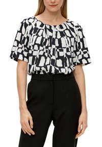 Blouse in zwart en wit met abstract patroon, ronde halslijn, korte mouwen en geplisseerde voorkant. Draagt het met zwarte, op maat gemaakte broek.