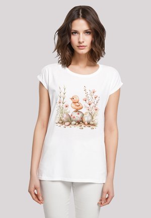 Weißes T-Shirt mit kurzen Ärmeln, das eine bunte Illustration eines Enten und dekorierten Eiern zeigt, umrahmt von Blumen- und Grashintergrund.