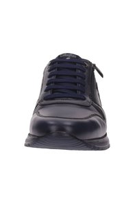 Zapatilla de cuero azul marino con punta redonda, lengüeta de malla texturizada y cordones elásticos, con un cierre lateral y suela acolchada.