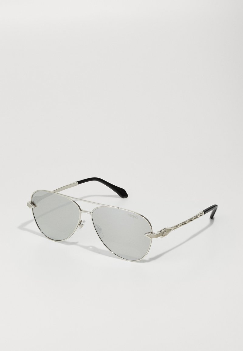 Silver metal sunglasses with grey lenses, angular aviator shape, black temple tips, and patterned detailing on the side arms.