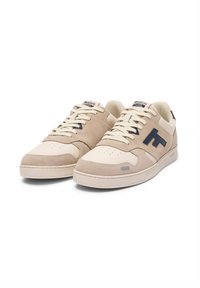 Sneaker in suede beige con punta in pelle bianca. Presenta un marchio blu scuro, lacci panna, punta perforata e suola in gomma.
