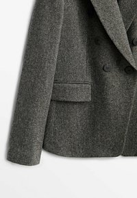 Blazer grigio a tweed con tessuto strutturato, design doppiopetto, rever strutturati e bottoni neri. Presenta un dettaglio di tasca laterale.