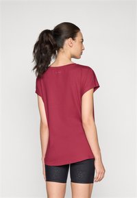 T-shirt corto color bordeaux realizzato in tessuto morbido, con un collo rotondo e un fit morbido, abbinato a pantaloni bike neri.