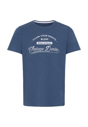 Sininen lyhythihainen t-paita, joka on valmistettu pehmeästä kankaasta, jossa on pyöreä pääntie ja graafiset tekstit: "Vaatimuksesi", "Sekoita" ja "Vintage Denim".