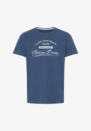 Sininen lyhythihainen t-paita, joka on valmistettu pehmeästä kankaasta, jossa on pyöreä pääntie ja graafiset tekstit: "Vaatimuksesi", "Sekoita" ja "Vintage Denim".