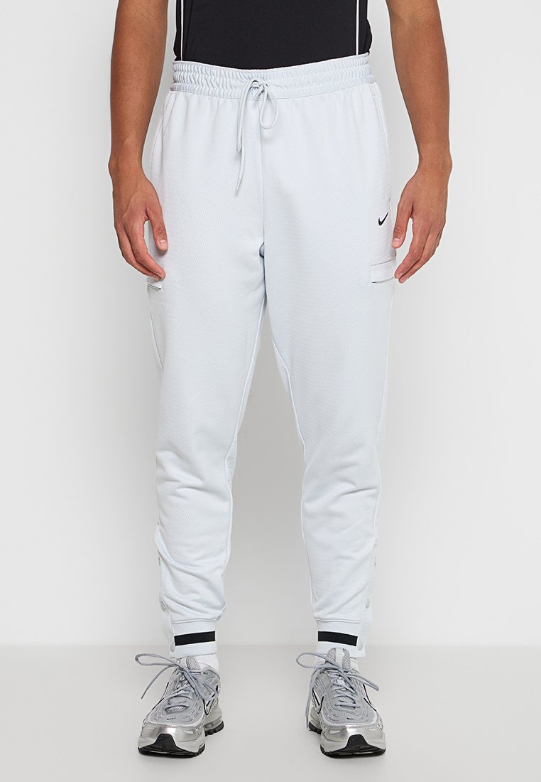 Lichtgrijze sportjoggers met een elastische tailleband, zijzakken en zwarte accenten op de boorden. Gemaakt van gestructureerde, ademende stof.