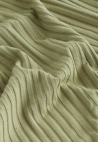 Tissu tricoté côtelé vert clair avec des plis doux et une texture de couture verticale visible.