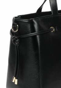 Sort læder tote bag med en tekstureret overflade, guld hardware detaljer og knyttet snørelukning. Håndtag til bæring.