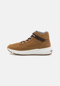 Brązowe zamszowe sneakersy typu high-top z wyściełanym szarym kołnierzem, białą podeszwą i ciemnobrązowymi akcentami. Posiadają sznurowanie oraz detal z logo.