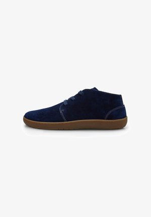 Botine antrena din suede navy cu o textură netedă, vârf rotund, șireturi simple și talpă din cauciuc maro deschis.