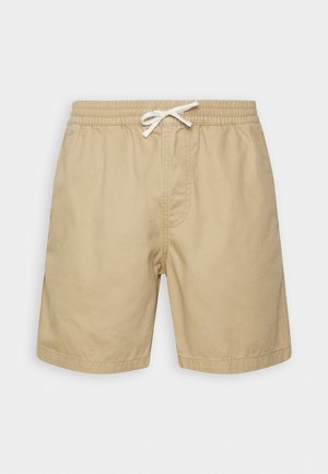Beige Baumwollshorts mit einem elastischen Bund, Kordelzug und zwei seitlichen Taschen. Glatte Textur, knielanges Design.