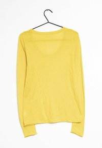 Żółty sweter z długim rękawem na czarnym wieszaku na białym tle, pokazany od tyłu.