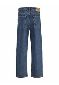 Jean en denim avec une coupe décontractée, couleur bleu foncé, cinq poches et une étiquette en cuir à logo sur la ceinture arrière. Texture usée sur l'ensemble.