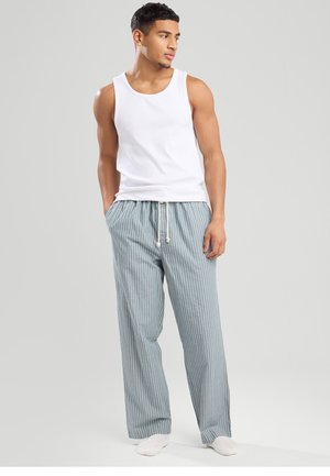 White tank top with round neckline, paired with light blue, striped pajama pants featuring a drawstring waist and loose fit.