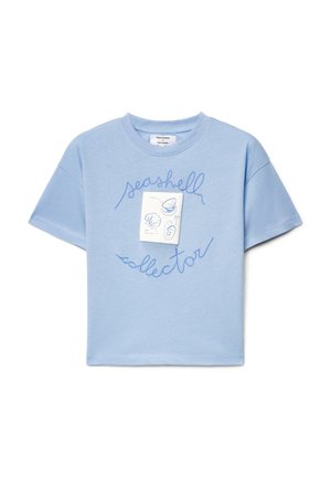 T-shirt di cotone azzurro chiaro con maniche corte e collo rotondo, con la scritta "collezionista di conchiglie" in corsivo blu e un'etichetta bianca.