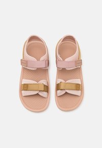 Rosa und beige Sandalen mit einer strukturierten Sohle, verstellbaren Riemen und einem weichen Futter, entworfen für Komfort und Stabilität.