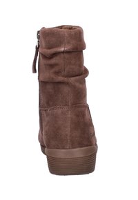 Bota de tobillo de ante marrón con diseño arrugado, cremallera lateral y suela de goma texturizada, con interior acolchado para mayor comodidad.