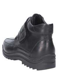 Schwarze Leder-Ankle-Boots mit einer strukturierten Oberseite, Klettverschluss und einer robusten Gummisohle mit einem dicken Profil.