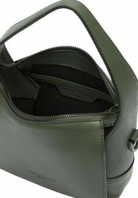 Sac à main en cuir vert avec une fermeture éclair, une anse unique et des compartiments intérieurs. Texture lisse avec un détail de marque subtil à l'intérieur.