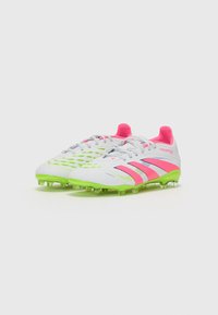 White soccer cleats with pink accents and green soles. Features a textured upper and a lace closure, designed for performance on the field.