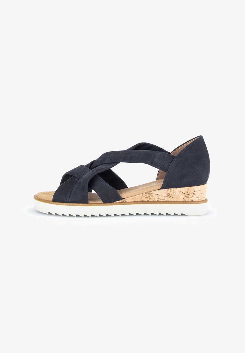Donkerblauwe suède wedge sandalen met een crisscross bandontwerp, kurk-textuur hak en een witte rubberen zool met een getande rand.