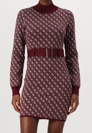 Robe en maille bordeaux à manches longues avec motif géométrique blanc, col montant, large ceinture assortie avec boucle argentée, portée par une personne debout.