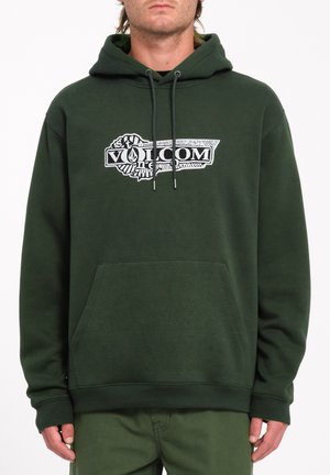 Sudadera verde con bolsillo frontal, cordones y un logotipo gráfico central en blanco y negro. La tela parece suave con un acabado texturizado.