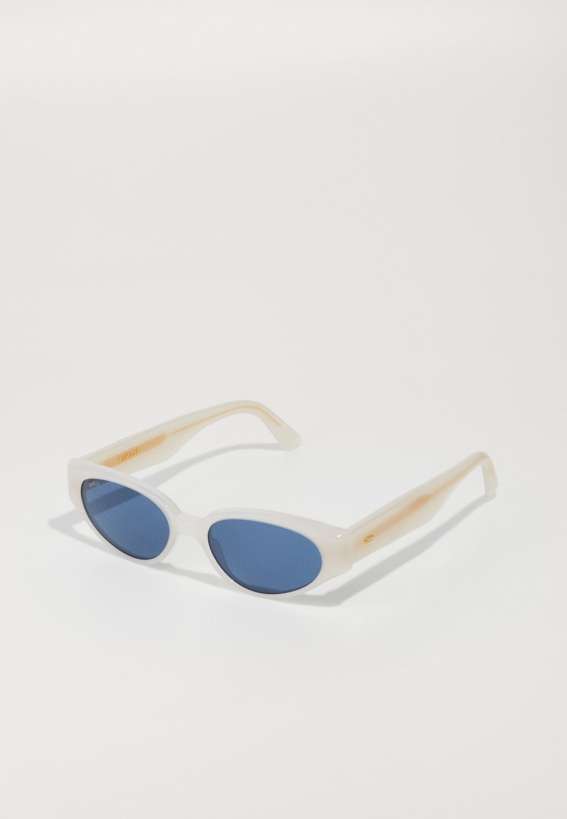 White oval sunglasses with blue tinted lenses. Frames feature a translucent finish with a slight gradient towards the temples. Gold detailing present.