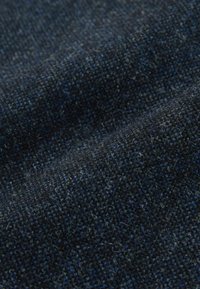 Ciemna, teksturowana tkanina o tkanym wzorze, łącząca granatowe i niebieskie odcienie, miękka w dotyku z delikatnym meszkiem.