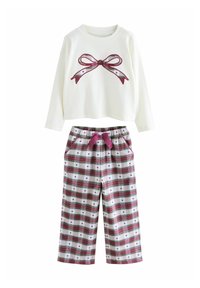 Setet inkluderar en krämfärgad långärmad topp med en röd rosettgrafik och mönstrade rutiga byxor i vitt, grönt och rött med midja som kan dras åt med snöre.