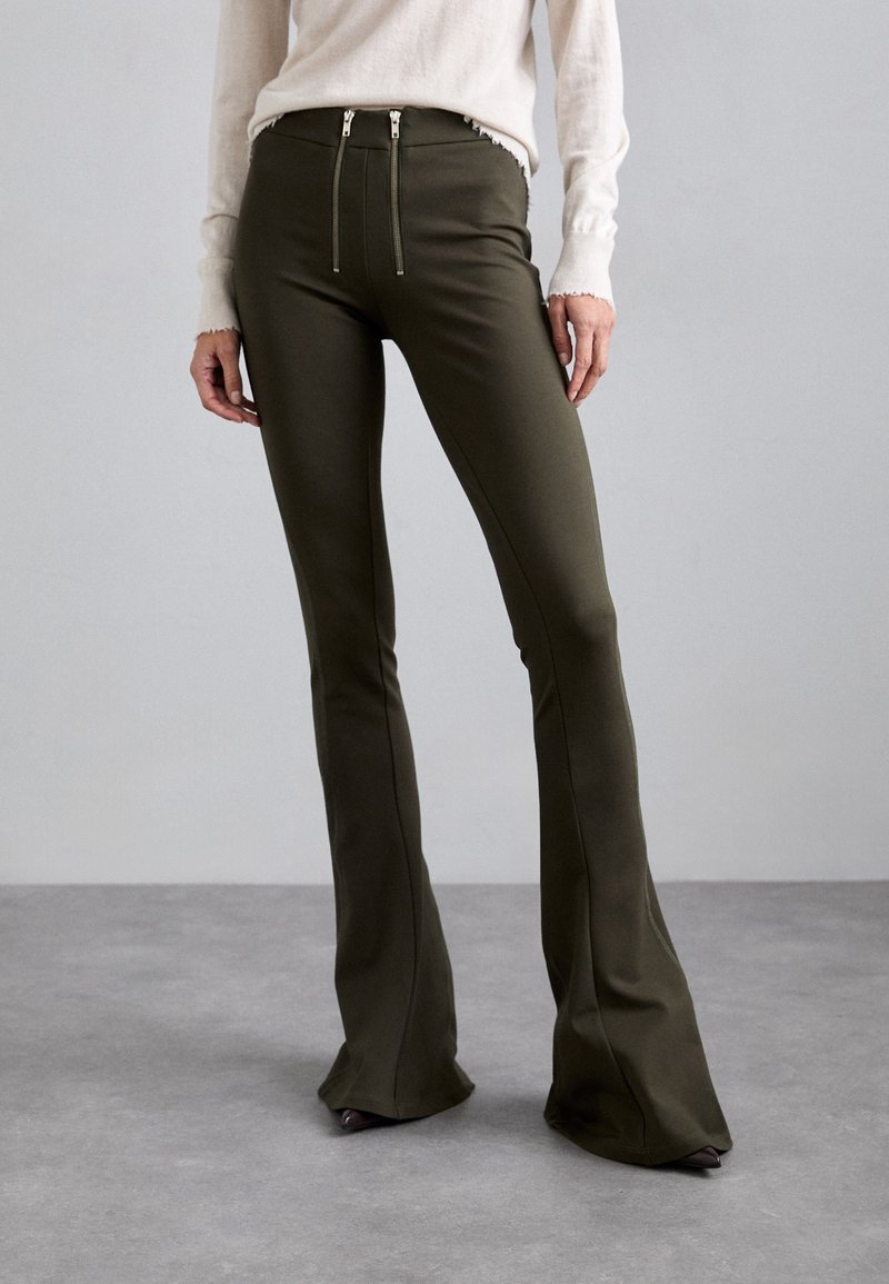 Olijfgroene uitlopende broek met twee ritssluitingen aan de taille, gemaakt van een soepele, rekbare stof, met schone naden en een getailleerde pasvorm.