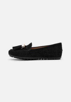 Mocassins en daim noir à bout rond, ornés d'un pompon avec accents dorés et d'une semelle en caoutchouc texturée pour une meilleure adhérence. Conviennent pour un usage décontracté.