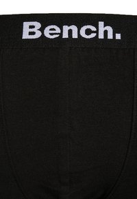 Fekete, rugalmas anyagból készült boxernadrág, szőtt elasztikus derékpánttal, amelyen világoskék "Bench." logó található. Simító textúrájú, testhezálló fazon.