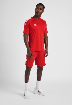 Rode sportieve shirt en shorts set, met korte mouwen, een ronde hals en witte zigzagaccenten op de shorts. Gemaakt van lichtgewicht stof.
