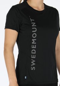 Black short-sleeve athletic shirt featuring reflective text "SWEDEMOUNT" on the side and a small Swedish flag accent at the hem.
