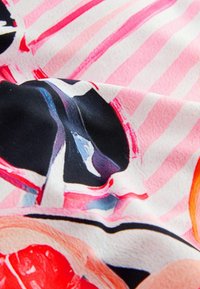Tessuto colorato con motivi floreali con accenti rosa e neri su uno sfondo a strisce chiare, principalmente in tonalità di rosa e bianco.