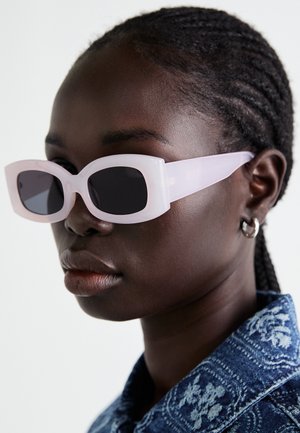 Różowe, przezroczyste okulary przeciwsłoneczne o kwadratowych oprawkach i ciemnych soczewkach, z gładką teksturą i szerokimi zausznikami.