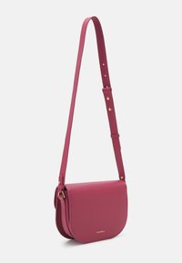 Borsa a tracolla in pelle rosa con design a patta curva, tracolla regolabile e accessori in metallo dorato. Finitura testurizzata su tutta la superficie.