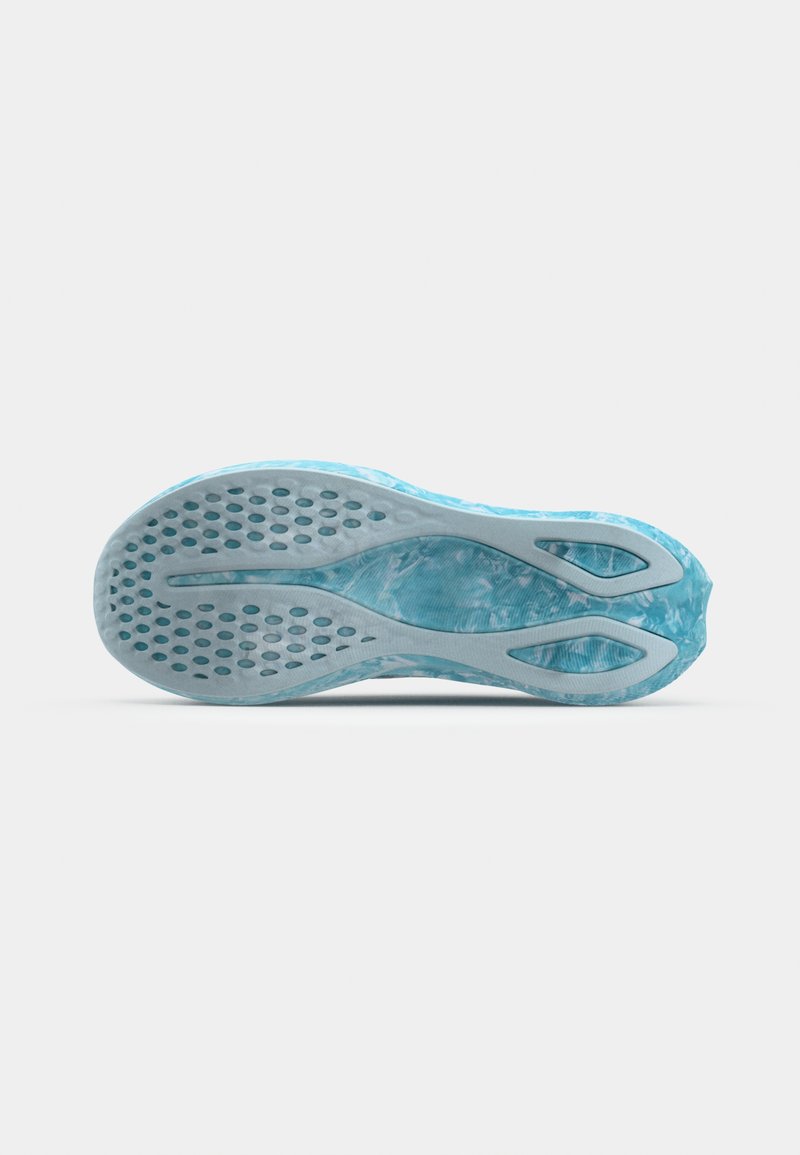 Blauwe sneakeronderzijde met een gestructureerd patroon en cirkelvormige uitsparingen voor grip, gebogen zijkanten en een gladde blauwe tussenzool.