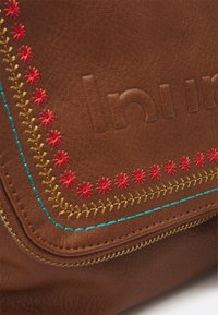 Brun lædertaske med farverig broderi i rød og blå, med en tekstureret overflade og et let forhøjet logodetalje.